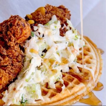 Chicken and Waffle - Buttermilk Waffle Topped with Two Buttermilk Fried Chicken Tenders, Country Cole Slaw, Roasted Corn Relish and 100% Maple Syrup.
